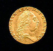 Gold coin bearing the profile of a round-headed man wearing a classical Roman-style haircut and laurel-wreath.